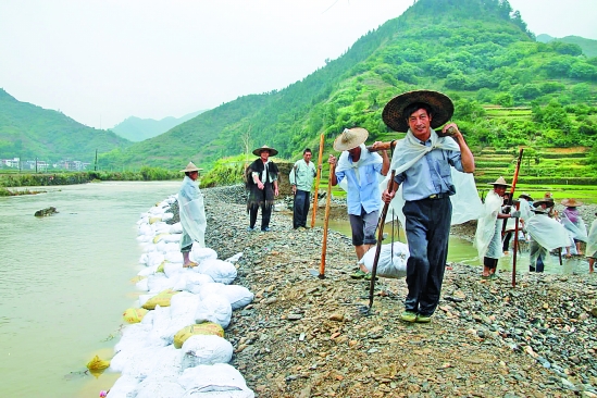 6月20日下午,洪水退去.开化县村头镇孔山村立即抢修被冲毁的河坝.